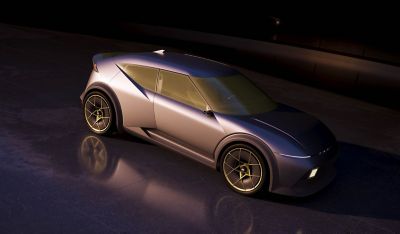 Hyundai Concept THREE viewed from above in a dimly lit setting, showcasing its sharp lines, wide stance, and yellow alloy wheels.