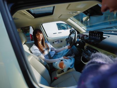 Un hombre y una mujer sentados en el espacioso asiento trasero del nuevo coche eléctrico Hyundai INSTER.