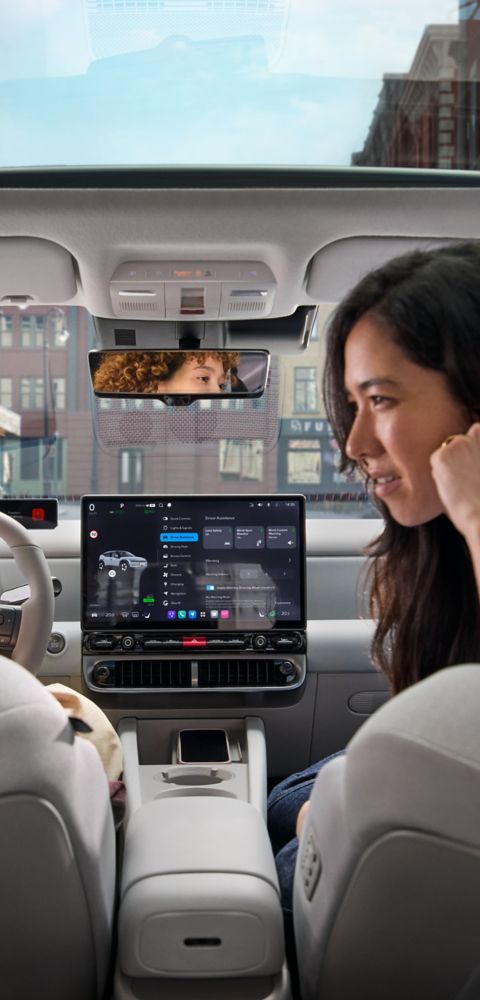 Kupén i Hyundai IONIQ 3 med två personer i framsätena och glastaket synligt.