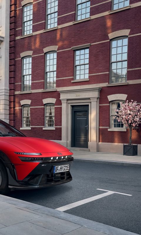 Röd Hyundai IONIQ 3 N Line parkerad på en stadsgata.