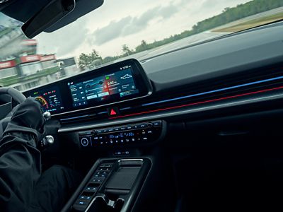 Primo piano dell'abitacolo della IONIQ 6 N durante la guida, con particolare attenzione all'interfaccia digitale interattiva.