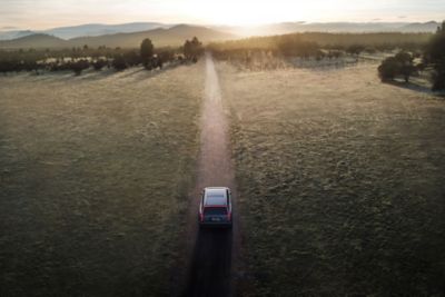 Elektryczny SUV Hyundai IONIQ 9 jadący polną drogą, widziany z lotu ptaka.