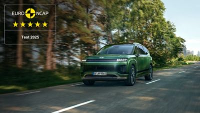 A Hyundai IONIQ 9 on a forest road with EURO NCAP badge showing 5-star rating.