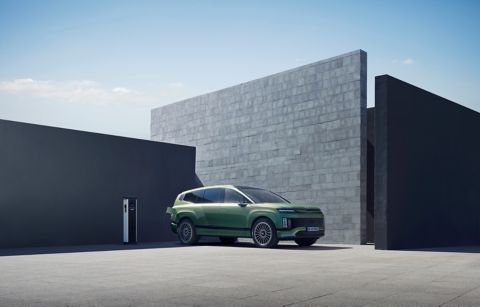 Hyundai IONIQ 9 electric SUV plugged into charge in front of a house.