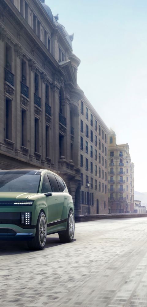 Three-quarter view of the Hyundai IONIQ 9 driving in the city.