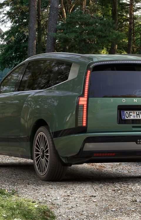 Rear view of the Hyundai IONIQ 9 electric SUV parked at a campsite.