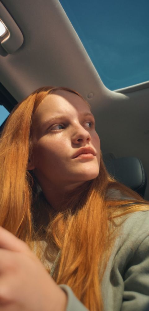 Hyundai IONIQ 9 interior with panoramic sunroof and seated person looking to the side