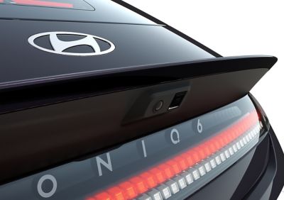 Gros plan du logo arrière de l'IONIQ 6 et des pixels paramétriques illuminés à l'arrière.