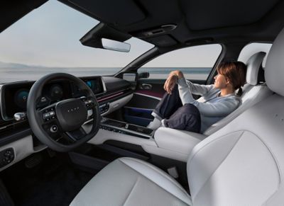 Une femme se détend sur le siège passager avant de la Hyundai IONIQ 6.