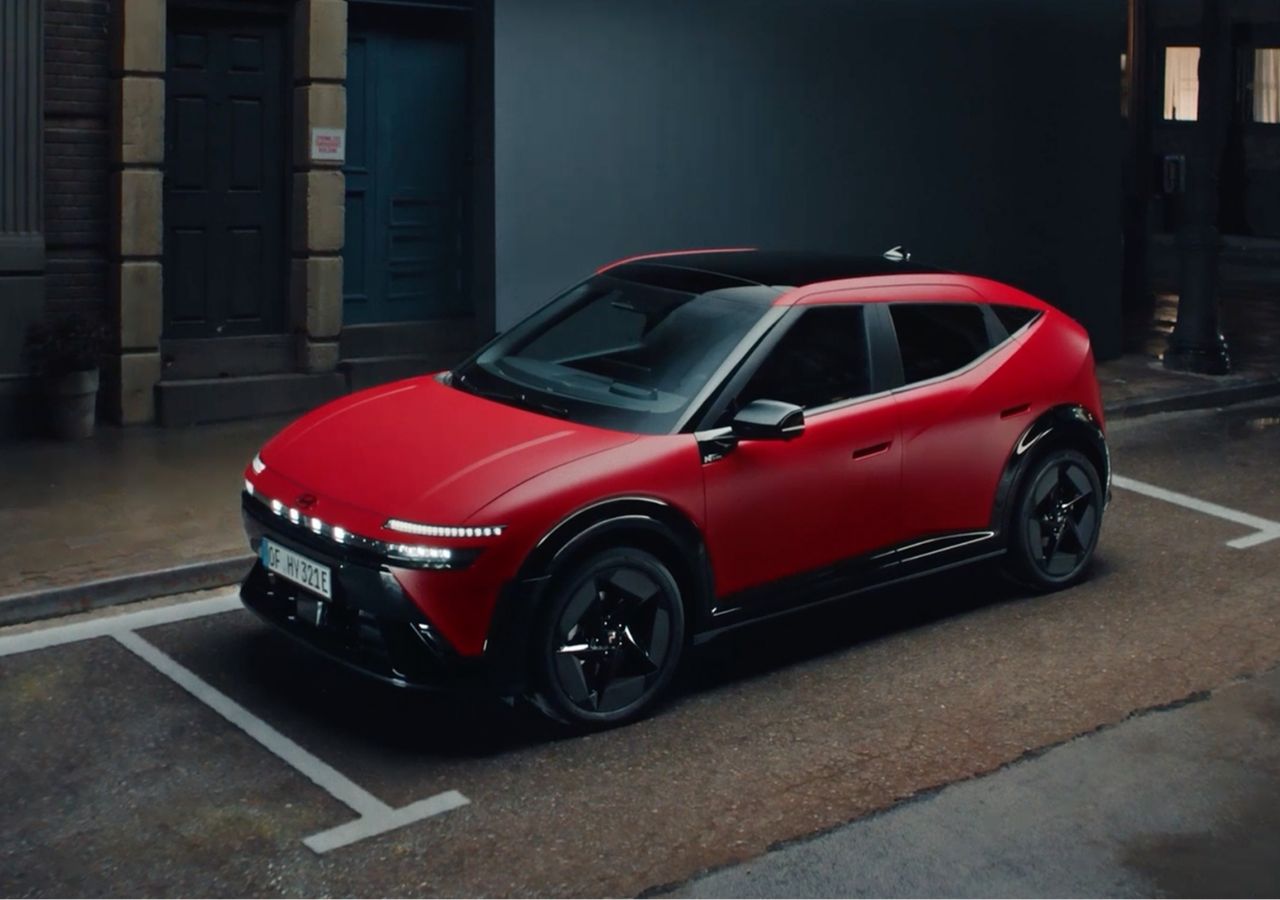 Röd Hyundai IONIQ 3 N Line sedd från sidan, parkerad på en stadsgata.