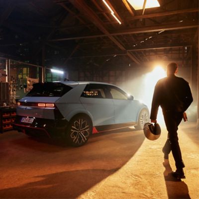 The Hyundai IONIQ 5 N parked in a garage with man walking towards the vehicle.