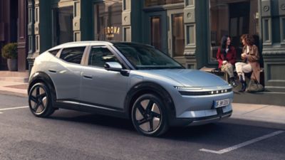 Hyundai IONIQ 3 parkerad på en stadsgata med två personer intill bilen.