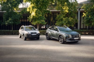 The Hyundai TUCSON 20th Anniversary Edition parked next to a 2005 Hyundai TUCSON.	