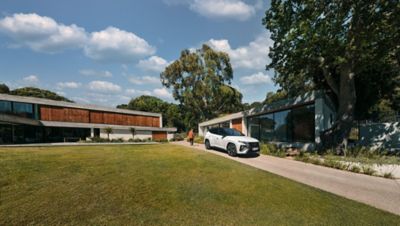 Nouveau TUCSON Hybrid N Line garé dans une allée devant une maison moderne