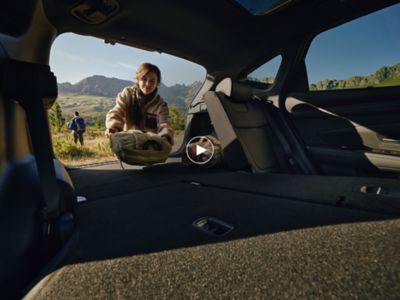 Une femme range des objets dans le coffre du Hyundai TUCSON Plug-in Hybrid.
